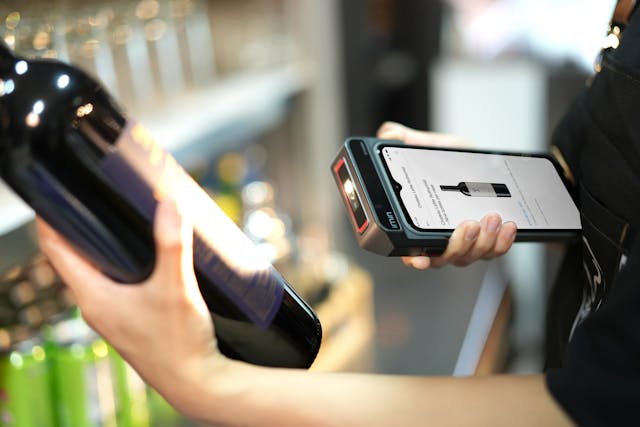 A staff Using Scanner on Bottle of Wine
