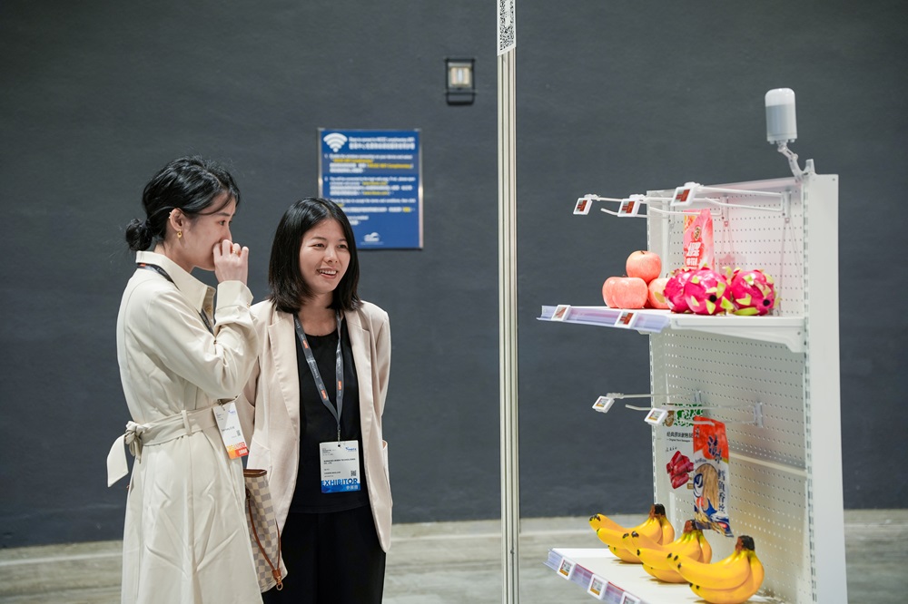 Minewtag representatives introduce electronic shelf labels to customers at the exhibition.